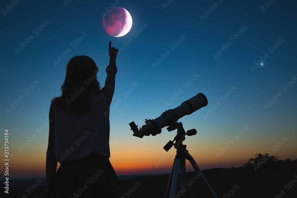 Obraz premium Dziewczyna patrząc na zaćmienie Księżyca przez teleskop. Moja praca z astronomią.