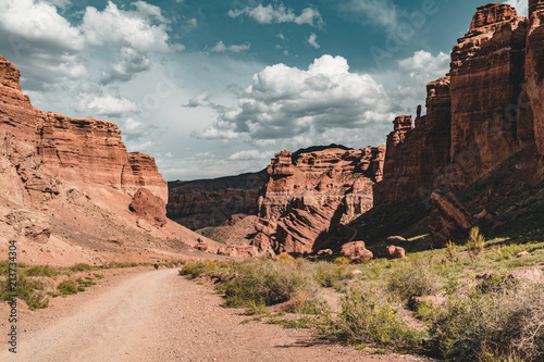 Charyn Grand Canyon with clouds and sun red orange stone Martian landscape