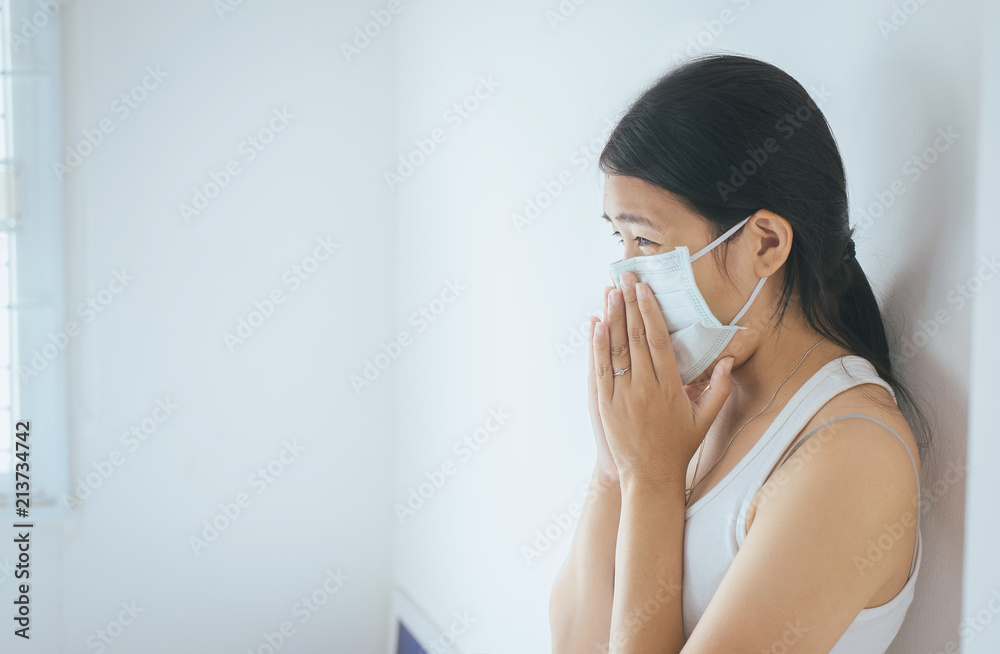 Concept of health woman using protective mask with cold blowing and runny nose on bed,sick woman sneezing Concept of health woman using protective mask with cold blowing and runny nose on bed,sick woman sneezing