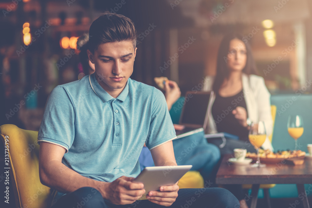 Fototapeta premium Young male using digital tablet in modern startup office