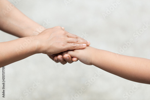 hand of parent and child on the background blurred nature.Mother holding hands baby © photosky99