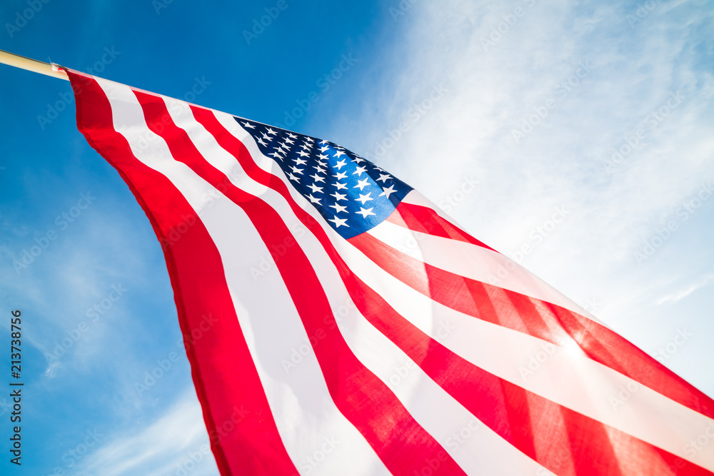 Fototapeta premium Close up United States of America flag on the blue sky background. USA Independence day, 4 July.