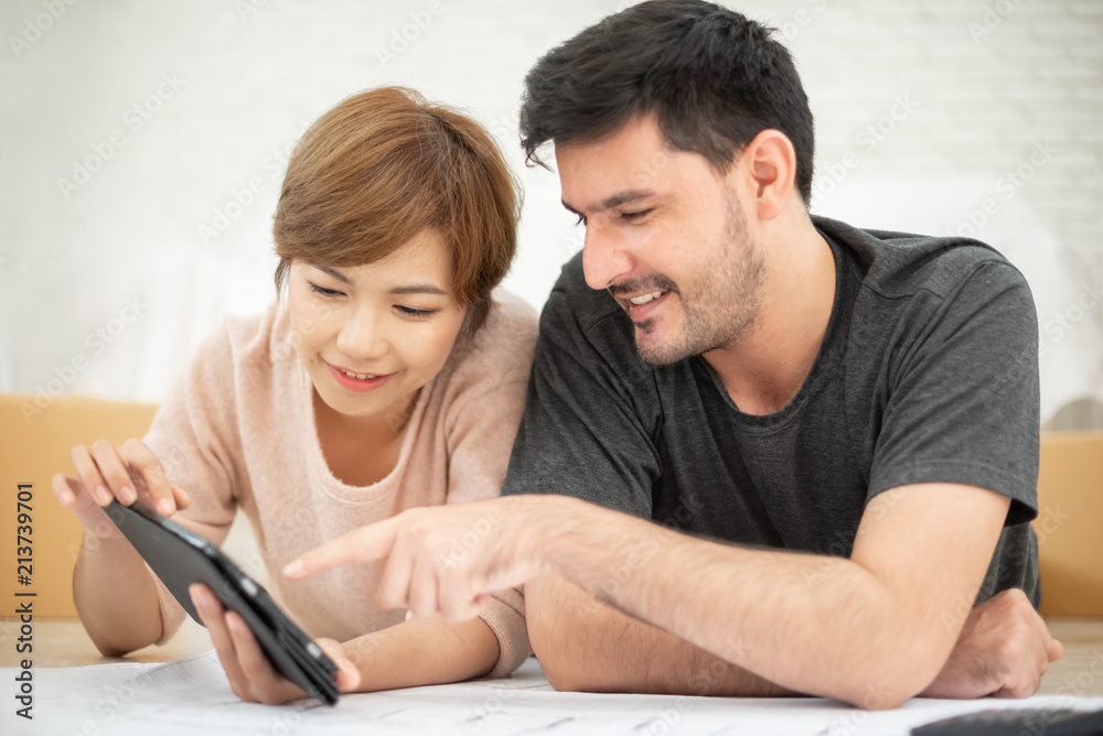 Couple with digital tablet and blueprints planning their new moving house. Couple with digital tablet and blueprints planning their new moving house.