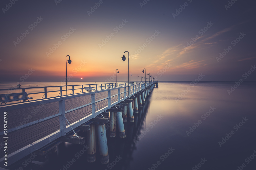 Obraz premium Amazing colorful sunrise over the pier in Gdynia Orlowo. Sunrise over the sea.