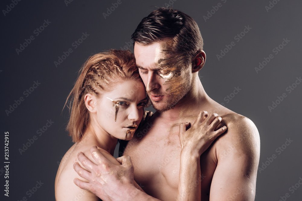 Adult. Adult couple in love with gold painted body and face embracing. Adult. Adult couple in love with gold painted body and face embracing.