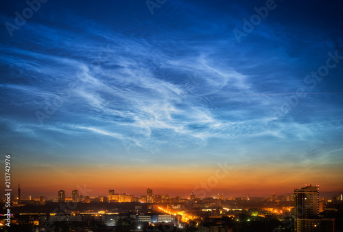Noctilucent clouds over the city downtown at summer night