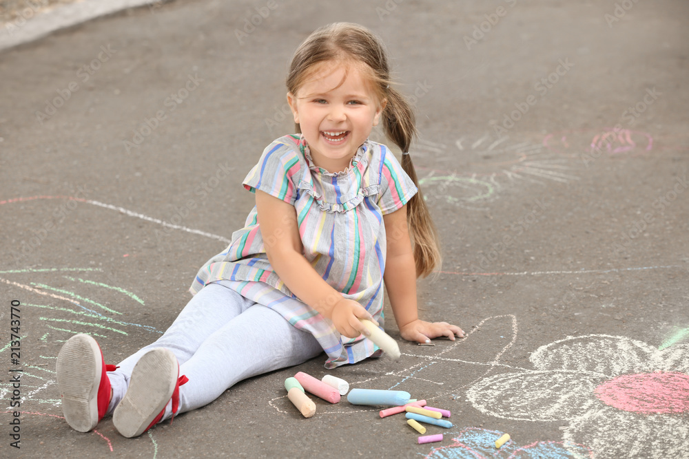 Fototapeta premium Cute little girl drawing with chalk on asphalt