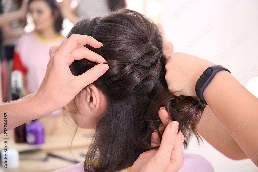 Fototapeta premium Professional hairdresser and trainee working with client in salon. Apprenticeship concept