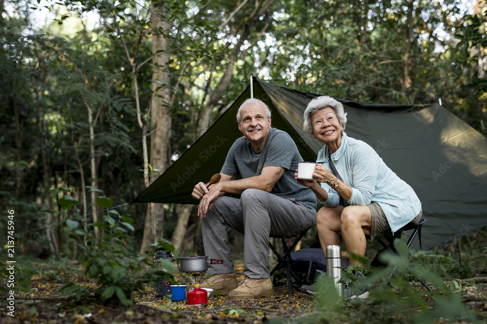 Senior friends having coffee at a campsite