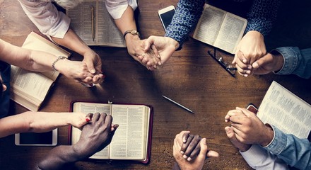 Group of people holding hands praying worship believe