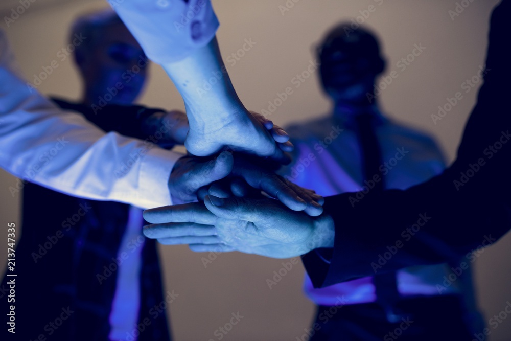 Hands join together in a group meeting