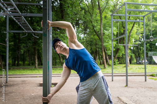 Attractive fitness man doing exercises in park