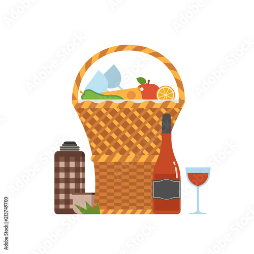 Wicker picnic basket with wine and french bread. Opened food hamper with blanket for romantic picnic.