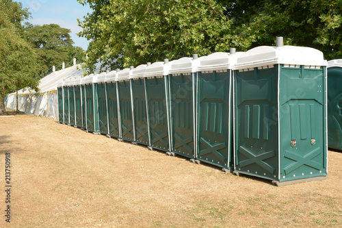 Rows of green portaloos or platic mobile toilets at festival photo