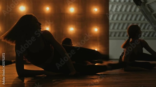 Silhouettes of dancing girls. go-go dance. Closeup dance performance of pretty female group on a dark stage with yellow lights. team dance of women in high heels.