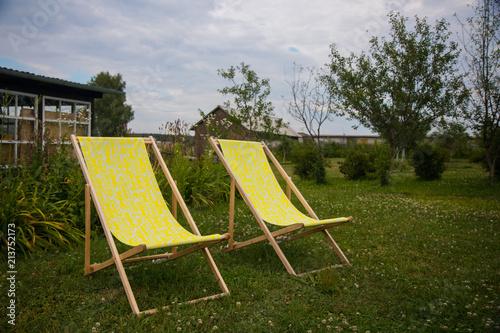 Two yellow chairs in the summer green garden for relax