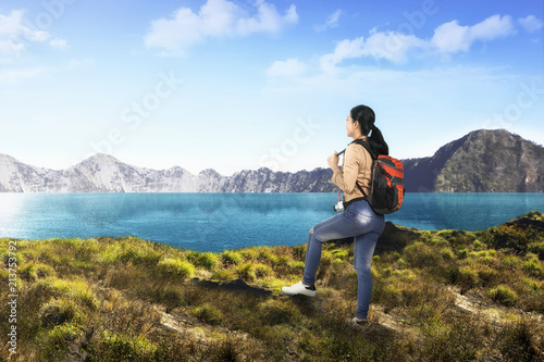 Young asian traveler woman with backpack looking at lake view