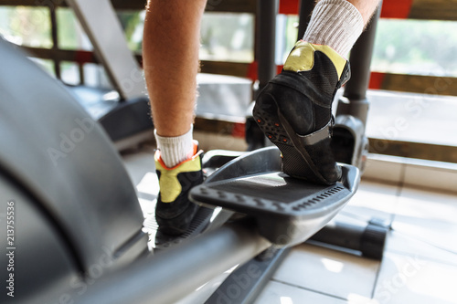 feet close-up, man riding a sports bike in the gym