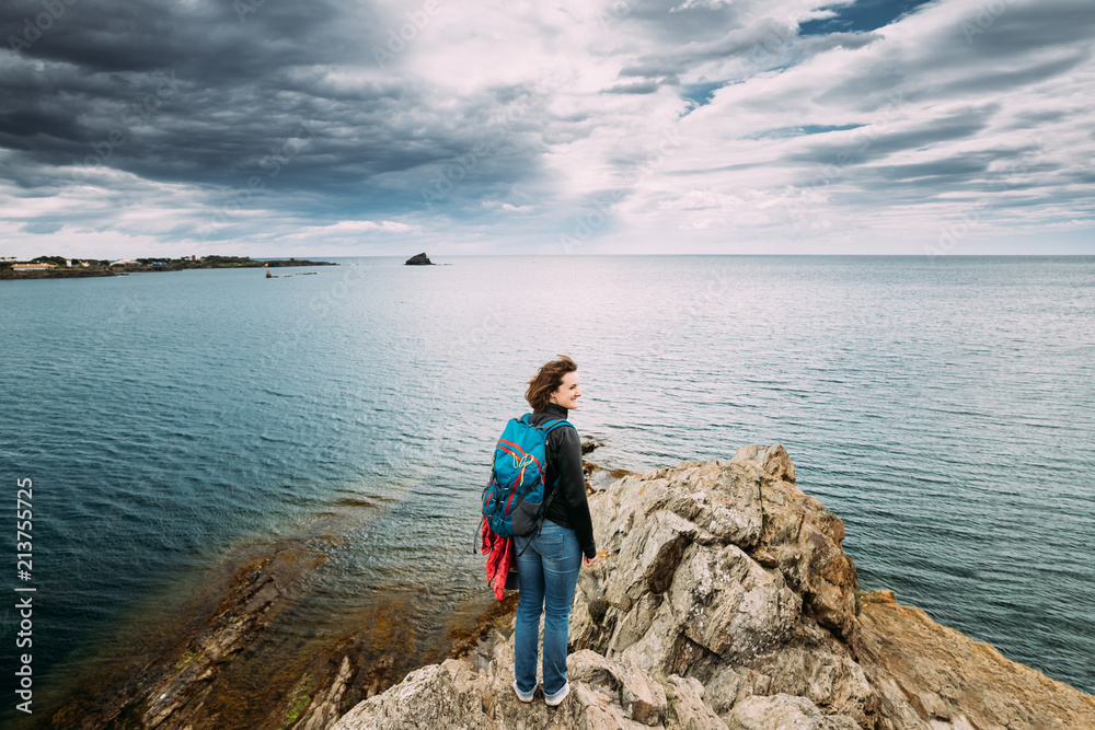 Young Woman Backpacker Hiker Enjoying Sea View On Top Of A Coast Young Woman Backpacker Hiker Enjoying Sea View On Top Of A Coast