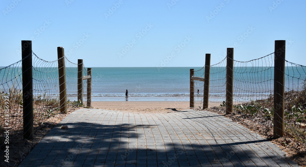 Fototapeta premium Sea beach wooden walkway path entrance. Sandy ocean beach entrance to Mindil beach, Darwin, Northern Territory of Australia.