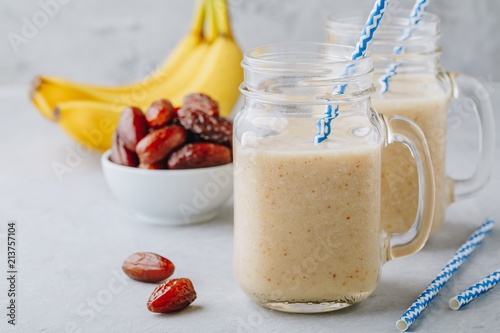 Banana and date fruit smoothie or milkshake in glass mason jar