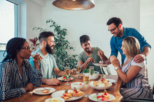 Tableau sur toile Group of multiethnic friends enjoying dinner party