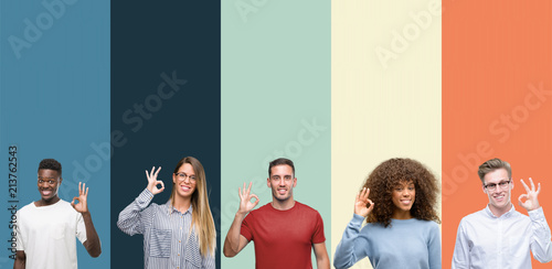 Group of people over vintage colors background smiling positive doing ok sign with hand and fingers. Successful expression.