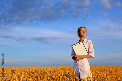 Agronomist or a student or a scientist with document in hand in the wheat field