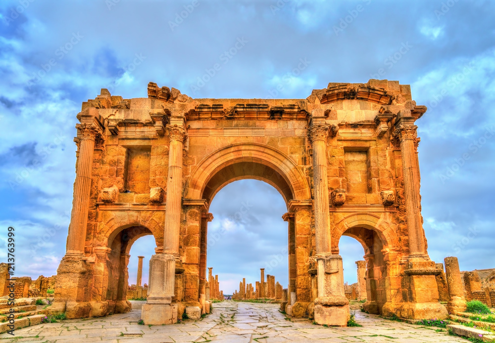 Trajan Arch within the ruins of Timgad in Algeria. - obrazy, fototapety, plakaty 