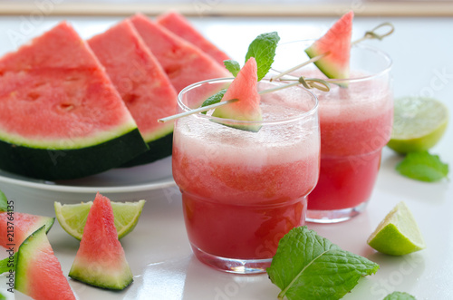 Watermelon smoothie with lemon and mint to cool down on hot days. Refreshening fruit drink to lose weight. Raw diet concept.