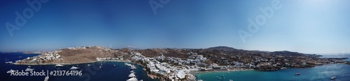 Aerial ultra wide panoramic drone view of iconic turquoise clear water beach of Psarou and Platy Yalos with yachts docked, Mykonos island, Cyclades, Aegean, Greece © aerial-drone