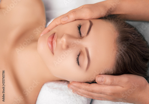 view from above attractive young woman enjoying a beauty facial treatment at a spa, close-up face with perfect fresh skin
