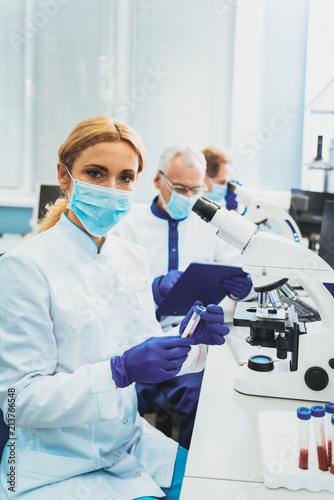 Medical uniform. Pretty female person wearing medical uniform while sitting at her workplace