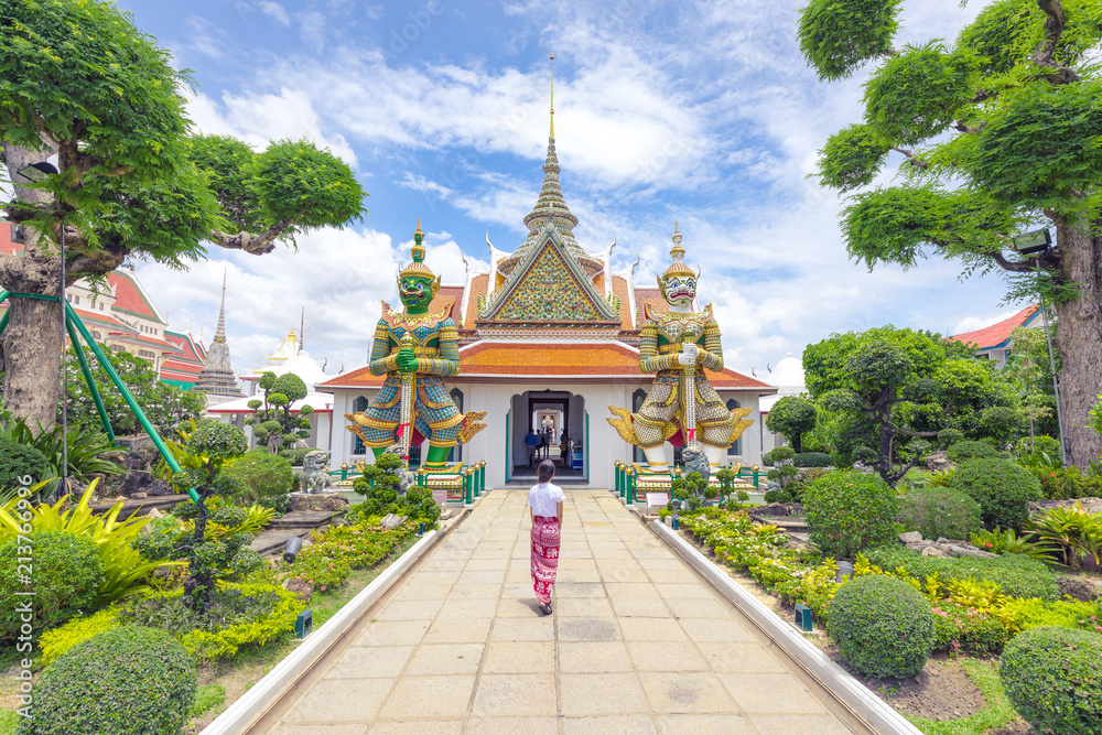 Women tourist visiting a temple in Thailand during a sunny day