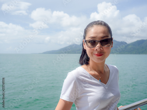 Asian woman on ferry looking at the sea view.