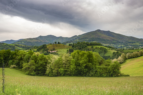 French Pyrenees Mountains view in early May, dramatic overcast sky, leaving Saint-Jean-Pied-de-Port, France