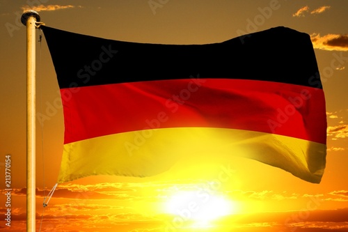 Germany flag weaving on the beautiful orange sunset with clouds background