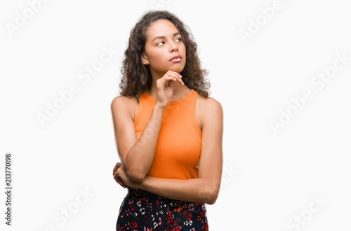 Young hispanic woman serious face thinking about question, very confused idea