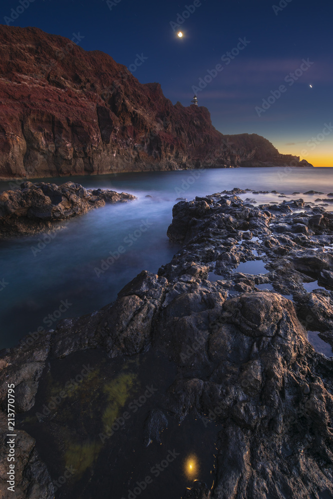 Rocky coastline with lighthouse on the moonset. Punte del Teno,tenerife
