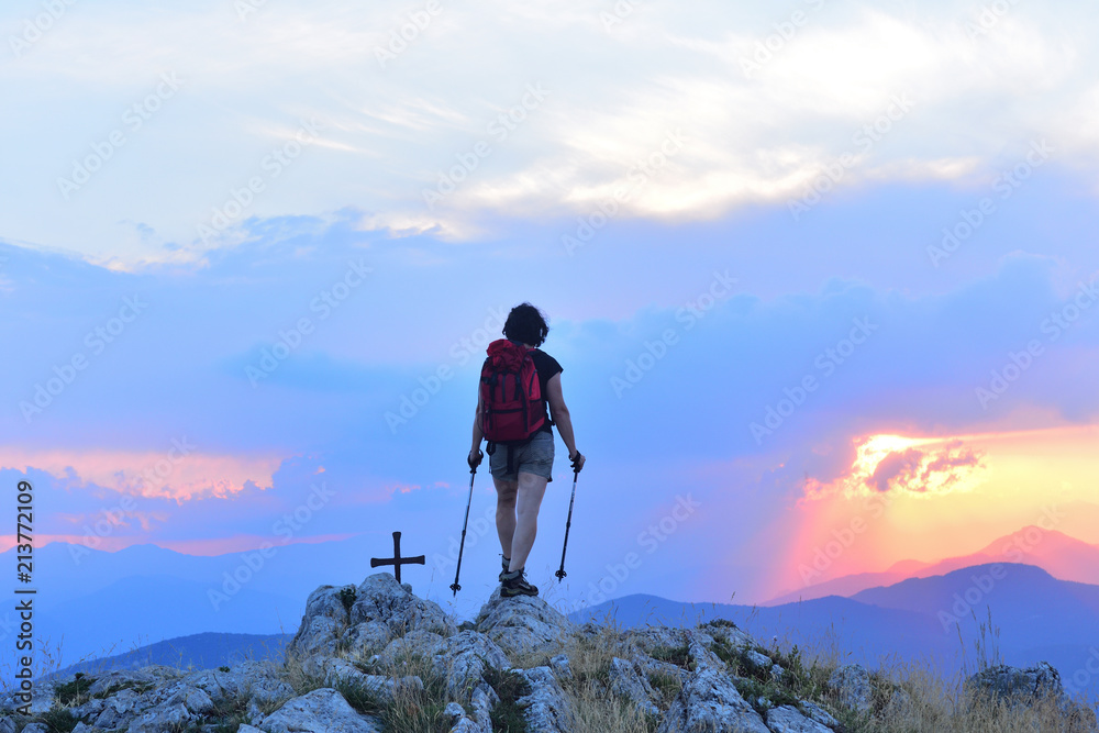 Woman who hiker reaches the top at sunset Woman who hiker reaches the top at sunset