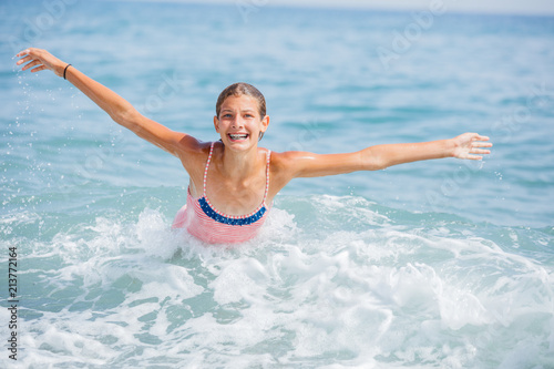Girl in swimsuit having fun on tropical beach photo