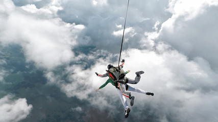 Fotobehang Luchtsport Tandem skydiven door witte wolken  © vladimirzhoga