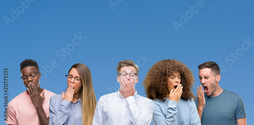 Composition of group of friends over blue blackground bored yawning tired covering mouth with hand. Restless and sleepiness.