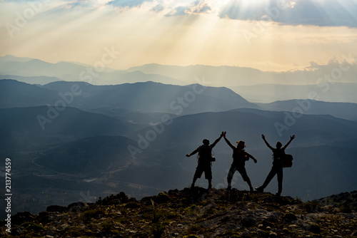 joyful happiness at the peak of three adult men and mountains
