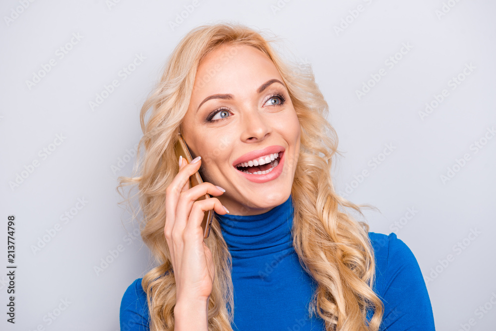 Portrait of pretty, trendy, charming, nice, sexy, cute, cheerful woman in blue turtleneck holding smart phone near ear, speaking on phone with friend, laughing, having fun, rest, relax, leisure Portrait of pretty, trendy, charming, nice, sexy, cute, cheerful woman in blue turtleneck holding smart phone near ear, speaking on phone with friend, laughing, having fun, rest, relax, leisure