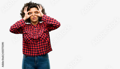 Beautiful arab woman looking at camera through fingers in ok gesture. Imitating binoculars