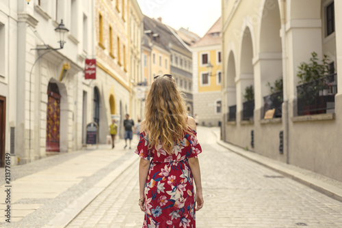 Young woman in red dress taking tour in old german town © seligaa