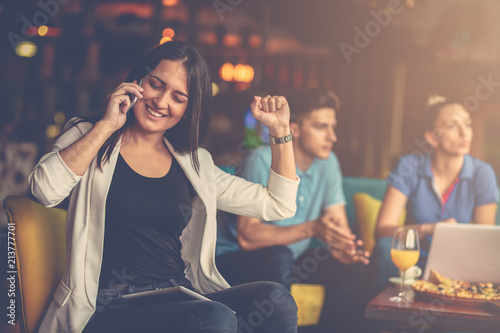 Young woman using mobile phone in front of her team in startup office