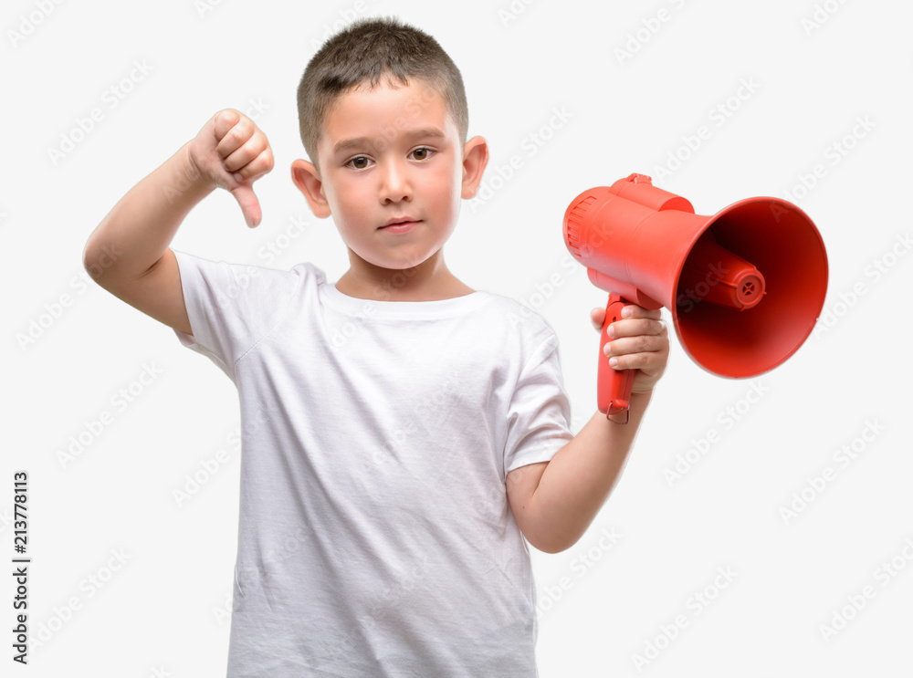 Dark haired little child holding megaphone with angry face, negative sign showing dislike with thumbs down, rejection concept Dark haired little child holding megaphone with angry face, negative sign showing dislike with thumbs down, rejection concept