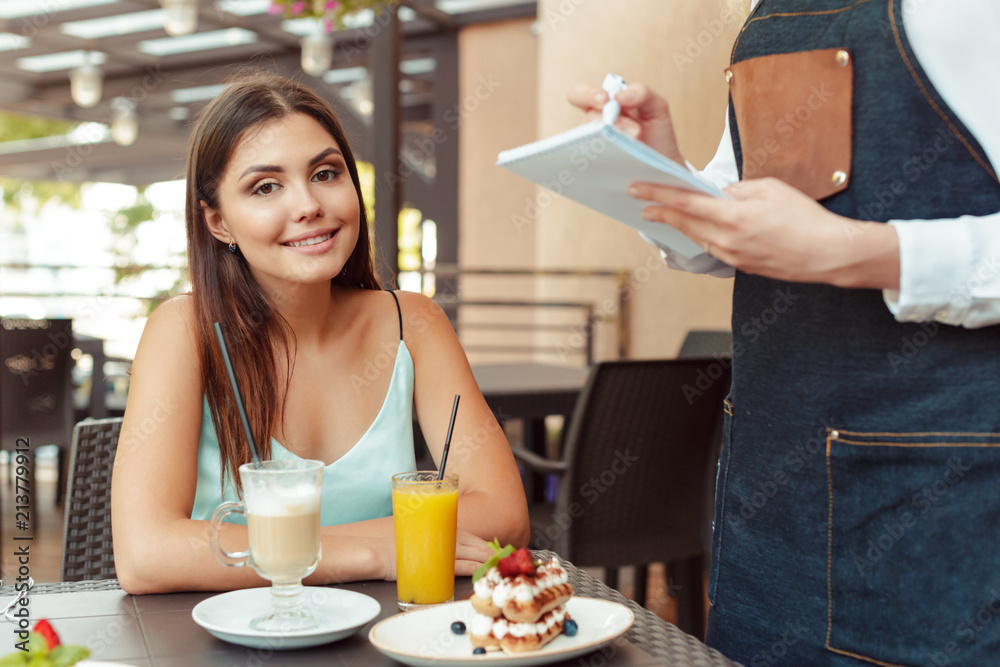 Waitress server helping client in cafe Waitress server helping client in cafe